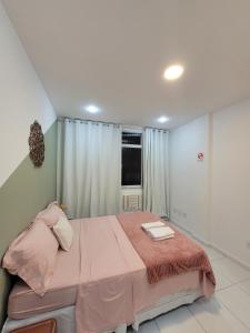 a bedroom with a pink bed with a window at Apê Jade, 400 m da praia de Copacabana in Rio de Janeiro