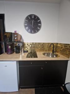 a clock on the wall above a kitchen counter at Suite GOLD Mulhouse in Mulhouse +22 photos