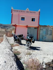 dos motocicletas estacionadas frente a un edificio rosa en Maison D'hôtes Chez Bassou Agoudal, en Agoudal