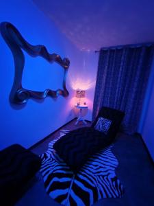 a bedroom with a zebra print bed with a blue light at Suite GOLD Mulhouse in Mulhouse