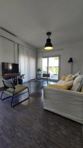 een woonkamer met een grote witte bank en een televisie bij Istron Avra in Kalo Chorio