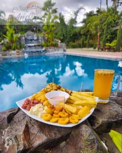 a plate of food and a drink next to a pool at La Quinta de Andrés in San Isidro