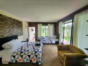 a hotel room with two beds and a chair at La Quinta de Andrés in San Isidro