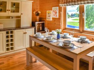 フリットン・ノーフォークにあるWild Grape Lodgeのキッチン(木製テーブル、食器付)