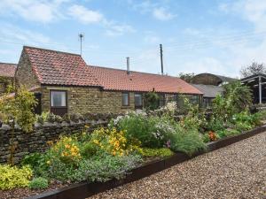 a stone house with a garden in front of it at Swallowdale Cottage in Levisham