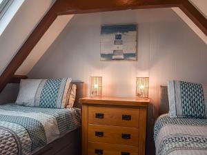 a attic bedroom with two beds and a wooden dresser at Harbour Hideout in Whitby