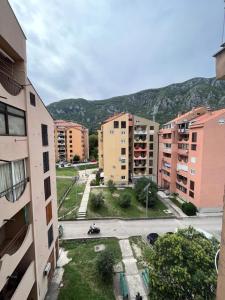 une ville avec des bâtiments et une montagne en arrière-plan dans l'établissement Orlando apartman, à Kotor