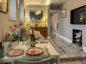 a dining room with a table with wine glasses at Acorn Cottage in Linton