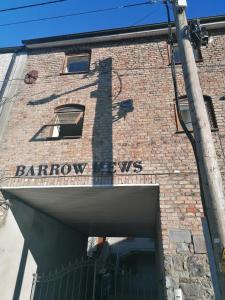 un bâtiment en briques avec un panneau au-dessus d'une porte dans l'établissement Barrow mews views, à Carlow