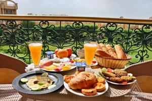 a table with plates of food and glasses of beer at Grand Museum Pyramids Inn in Giza