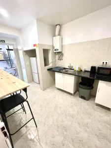 a kitchen with white cabinets and a black counter top at Lisboa Parque Guest House in Lisbon