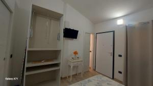 een witte kamer met een spiegel, een tafel en een deur bij B&B Sensorial Experience in Villamassargia