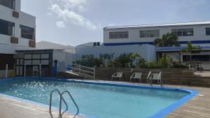 een groot zwembad met stoelen en een gebouw bij On Vacation Blue Tone in San Andrés
