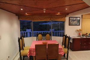 una sala da pranzo con tavolo, sedie e finestra di La casa dorada Guatavita a Guatavita