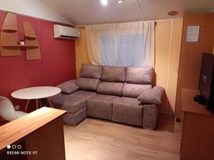 a living room with a couch and a table at Bungalows Buda Beach in Sanlúcar de Barrameda