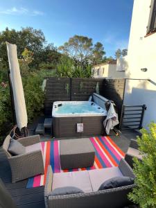 聖拉斐爾的住宿－Villa Les Mimosas Spa-Jacuzzi，庭院设有热水浴池、椅子和桌子
