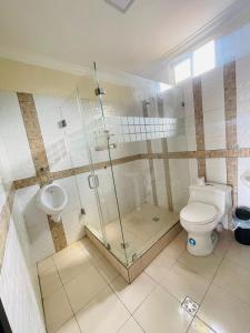 uma casa de banho com um chuveiro, um WC e um lavatório. em Confortable Apartamento em Puerto Francisco de Orellana