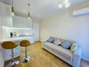 een witte woonkamer met een bank en een keuken bij Apartments Premium Center Tirana in Tirana