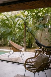 a patio with a hammock and a table and chairs at Zereno Boutique Hotel in Tulum