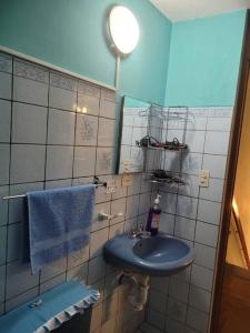 a bathroom with a blue sink and a mirror at Amplio y lindo departamento. in Arequipa
