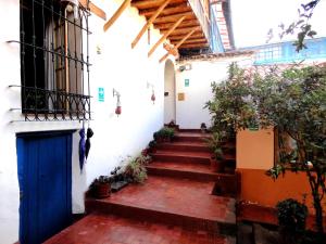 una escalera con una puerta azul y algunas plantas en Casona La Recoleta, en Cusco