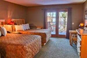 a hotel room with two beds and a balcony at Good Ol Days Resort in Nisswa