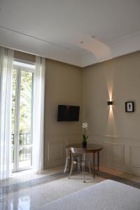 a living room with a table and a tv on the wall at Maccus Suite in Naples