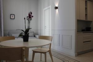 ein weißes Esszimmer mit Tisch und Stühlen in der Unterkunft Maccus Suite in Neapel