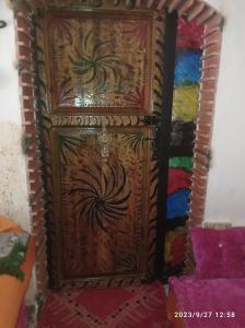 Una puerta de madera con una pintura. en Maison d'hotes Ait Bou Izryane en Timoulilt