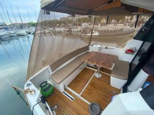 Séjour sur bateau de plaisance في ماندوليو لا نابول: قارب مع شرفة خشبية مع طاولة عليه