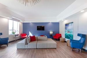 a living room with a couch and red chairs at Best Western Summit Inn in Niagara Falls