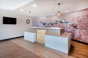 a lobby with a counter and a wall with art at Best Western Summit Inn in Niagara Falls