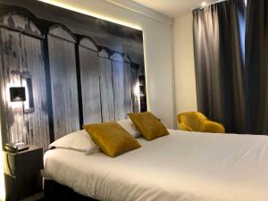 - une chambre avec un grand lit blanc et des coussins jaunes dans l'établissement Best Western ARThotel, au Havre