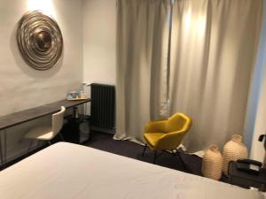 ein Schlafzimmer mit einem Bett und einem gelben Stuhl in der Unterkunft Best Western ARThotel in Le Havre