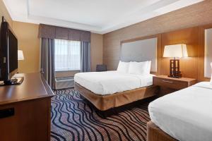 a hotel room with two beds and a flat screen tv at Best Western Summit Inn in Niagara Falls