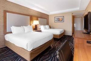 a hotel room with two beds and a flat screen tv at Best Western Summit Inn in Niagara Falls