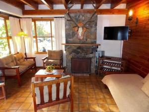 a living room with a fireplace and a couch and a tv at Cabañas Luz de Luna in San Martín de los Andes