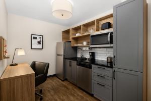 a kitchen with stainless steel appliances and a desk at Candlewood Suites - Layton - Salt Lake City, an IHG Hotel in Layton