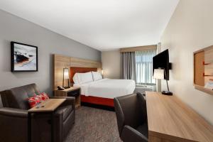 um quarto de hotel com uma cama, uma secretária e uma cadeira em Candlewood Suites - Layton - Salt Lake City, an IHG Hotel em Layton