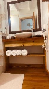 uma casa de banho com lavatório, espelho e toalhas em Utila Water Sports Deluxe Apt em Útila