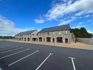 an empty parking lot next to a large brick building at Luxury hot tub & sauna apartment with pool table in the centre of northern ireland,sleeps 6 people in Coalisland