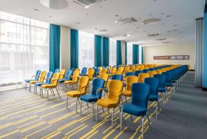 a room with chairs and blue and yellow chairs at Park Inn by Radisson Volgograd in Volgograd
