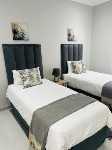 two beds in a room with white walls at Seaview Sanctuary in Durban