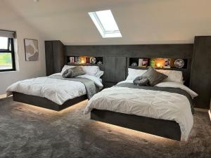 a bedroom with two beds and a skylight at Luxury hot tub & sauna apartment with pool table in the centre of northern ireland,sleeps 6 people in Coalisland