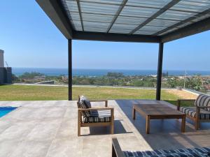 a patio with chairs and a table and a view at Seaview Sanctuary in Durban
