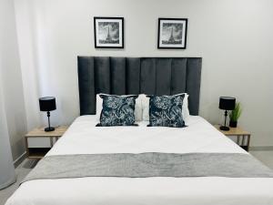 a bedroom with a large white bed with two lamps at Seaview Sanctuary in Durban