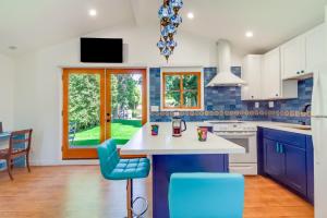 a kitchen with blue and white cabinets and blue chairs at Sleek Woodland Hills Retreat with Shared Pool and Yard in Woodland Hills