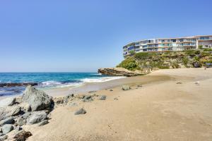 a beach with a building in the background and the ocean at Laguna Beach Escape with Hot Tub and Ocean Views! in Laguna Beach