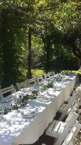 uma mesa longa com pratos e copos de vinho em Casa Quinta con Pileta en mercedes. 6 personas em Mercedes