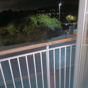 a white fence in front of a street at night at HomeStay Cosy Studio in Birmingham